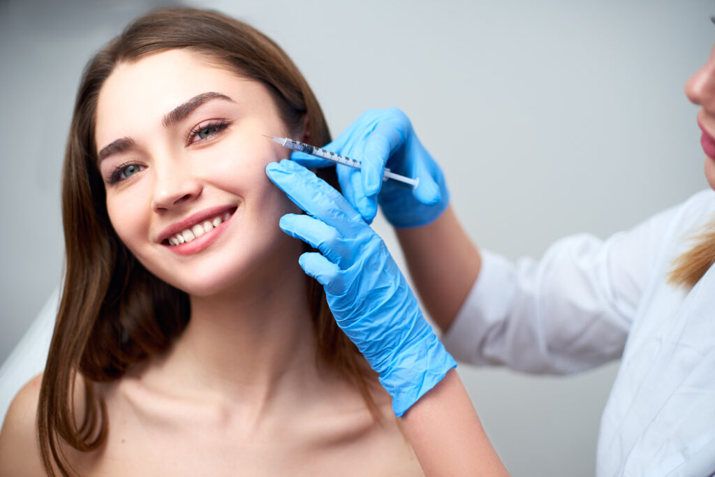 A photo of a brunette woman getting a dermal filler injection.